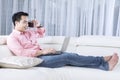 Man relaxing on sofa with laptop Royalty Free Stock Photo