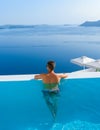 man relaxing in swimming pool during vacation at Santorini infinity looking out over the ocean Royalty Free Stock Photo