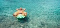 Man relaxing when swims on inflatable pineapple pool ring in crystal clear sea water. Careless vacation concept image