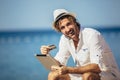 Man relaxing and use tablet computer and credit card at sea beach Royalty Free Stock Photo