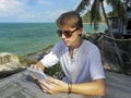 Man relaxing and use tablet computer at sea beach Royalty Free Stock Photo