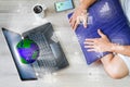 Man relaxing using internet via laptop computer with globe, networks, mobile phone with gps and hot coffee cup on wooden floor Royalty Free Stock Photo