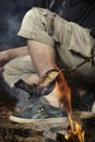Man relaxing in wilderness and preparing hunted fish on fire Royalty Free Stock Photo