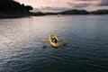 Man relaxing on yellow canoe in the lake at evening