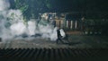 Man releasing smoke to clear up the mosquitoes and protect malaria in village at night Royalty Free Stock Photo