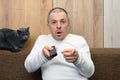 The man with the remote control in great amazement looking at the screen Royalty Free Stock Photo
