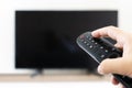 man with the remote control in hand watching the sports channel and presses the button on the remote control. Remote control in Royalty Free Stock Photo