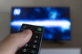 man with the remote control in hand watching the sports channel and presses the button on the remote control. Remote control in Royalty Free Stock Photo