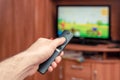 A man with a remote control in his hand is watching TV Royalty Free Stock Photo