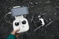 Man with remote control prepare white drone with digital camera for start flying.