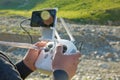 Man with remote control prepare white drone with digital camera for start flying in winter. Camera flying in sky over mountain Dro