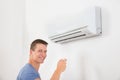 Man With Remote Control To Operate Air Conditioner Royalty Free Stock Photo