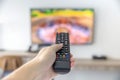 The man with the remote control watching TV and using remote controller and presses the button Royalty Free Stock Photo