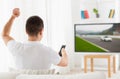 Man with remote watching motorsports on tv at home Royalty Free Stock Photo