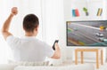 Man with remote watching motorsports on tv at home Royalty Free Stock Photo