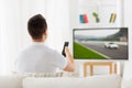 Man with remote watching motorsports on tv at home Royalty Free Stock Photo