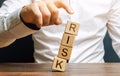 Man removes blocks with the word Risk. The concept of reducing possible risks. Insurance, stability support. Legal protection of Royalty Free Stock Photo