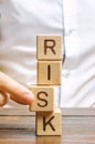 Man removes blocks with the word Risk. The concept of reducing possible risks. Insurance, stability support. Legal protection of