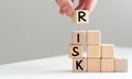 Man removes blocks with the word Risk. The concept of reducing possible risks. Insurance, stability support. Legal