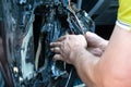 A man removes the door card to find a problem in the inoperative power window and repair it. Car repair at a service station