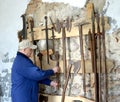 A man removes an old mace from a museum stand. Shaaken Castle, XIII century. Kaliningrad region