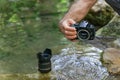 a man removes water from inside his reflex camera that has fallen into the river Royalty Free Stock Photo