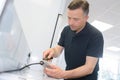 Man removing bubble-wrap packaging from electrical lead