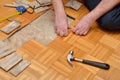 Man Removing Damaged Parquet in Apartment