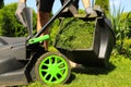 Man removing grass out of lawn mower box in garden, closeup Royalty Free Stock Photo