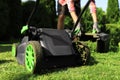 Man removing grass out of lawn mower box in garden, closeup Royalty Free Stock Photo