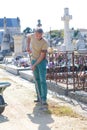 Man removing grass from path in graveyard