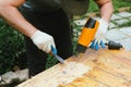 Man removing old varnish from wood using scraper and heat gun. Royalty Free Stock Photo