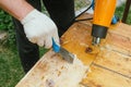 Man removing old varnish from wood using scraper and heat gun. Royalty Free Stock Photo