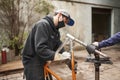 Man removing the paint of an orange bicycle frame during a bike renovation work Royalty Free Stock Photo