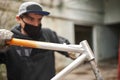 Man removing the paint of an orange bicycle frame during a bike renovation work Royalty Free Stock Photo