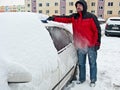 Man removing snow from car