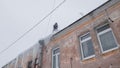 Man removing snow and icicles on the roof