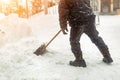 Man removing snow from sidewalk after heavy snowfall. Snowstorm and blizzard aftermath in winter. Slippery walkaway