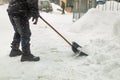 Man removing snow from sidewalk after heavy snowfall. Snowstorm and blizzard aftermath in winter. Slippery walkaway Royalty Free Stock Photo