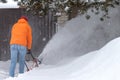 a man removing snow with a special blow machine with high waves Royalty Free Stock Photo