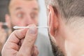 Man removing wax from ear using Q-tip Royalty Free Stock Photo