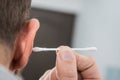 Man removing wax from ear using Q-tip Royalty Free Stock Photo