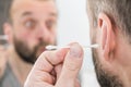 Man removing wax from ear using Q-tip Royalty Free Stock Photo