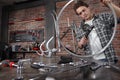 Man repair the bicycle in garage workshop on the workbench with tools, with the brush on the wheel, diy concept, red bricks Royalty Free Stock Photo