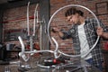 Man repair the bicycle in garage workshop on the workbench with tools, with the brush on the wheel, diy concept, red bricks Royalty Free Stock Photo