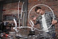 Man repair the bicycle in garage workshop on the workbench with tools, with the brush on the wheel, diy concept, red bricks Royalty Free Stock Photo
