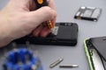 Man repairing cellphone with screwdriver