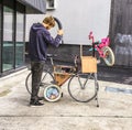 Man repairing a child`s bike on a mobile bicycle repair unit