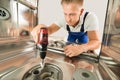 Man Repairing Dishwasher With Electric Drill Royalty Free Stock Photo