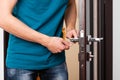 a man repairing a door knob. locksmith fixing a wooden door